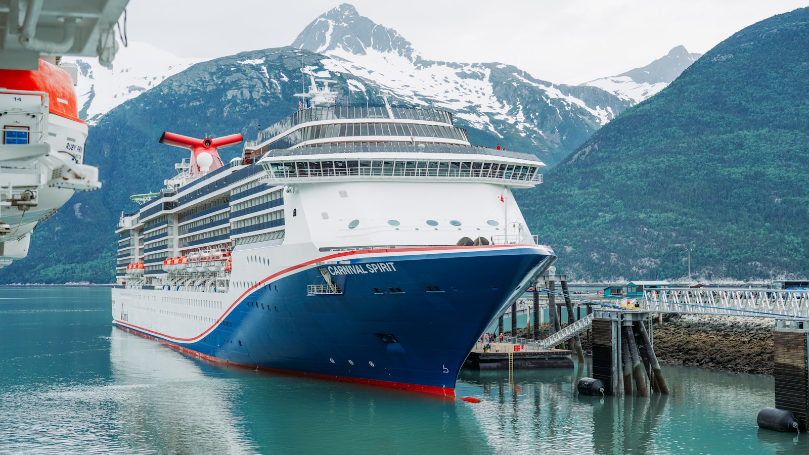 A cruise ship in a harbor with mountains in the background